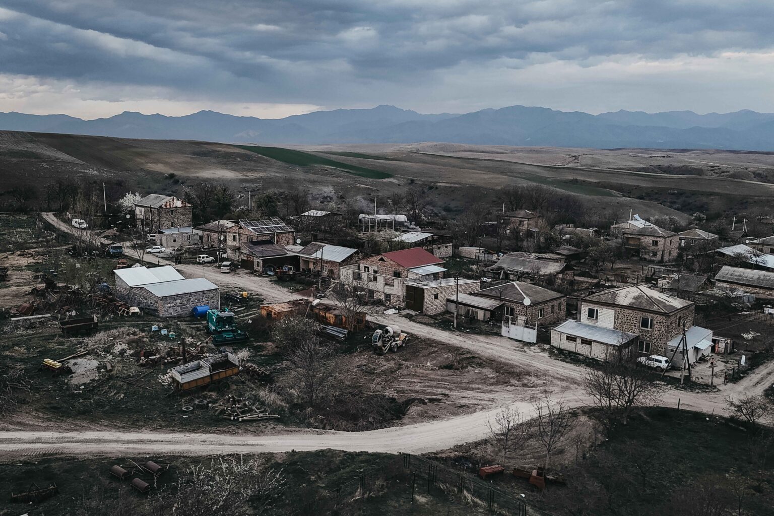 Vista Aérea del pequeño pueblo de Nerkin Khndzoresk a escasos 600 metros de la frontera con Azerbaiyán. Perteneciente a la provincia de Syunik y rodeada de granjas, campos de cultivo y caminos de tierra, se trata de una aldea dormitorio donde una gran cantidad de militares pernoctaban antes de enrolarse en las filas del ejército armenio en la guerra del Nagorno Karabaj.